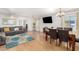 Open concept living and dining area with ceiling fans and light laminate floors at 19412 W Clarendon Ave, Litchfield Park, AZ 85340
