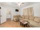 Comfortable living room with sectional sofa, laminate flooring, ceiling fan, and a view into adjoining spaces at 19412 W Clarendon Ave, Litchfield Park, AZ 85340