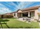 Charming backyard offers green turf, a fire pit, a covered patio, and a serene outdoor experience at 2065 N Red Clf, Mesa, AZ 85207