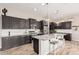 Spacious kitchen featuring dark cabinetry, stainless steel appliances, granite countertops, and an island with seating at 2065 N Red Clf, Mesa, AZ 85207