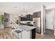Modern kitchen boasts a large island with granite countertops, stainless steel appliances and elegant pendant lighting at 2065 N Red Clf, Mesa, AZ 85207