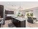 Open kitchen with dark cabinets, a large island with seating, stainless steel appliances, and backyard views at 2065 N Red Clf, Mesa, AZ 85207