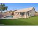 Beautiful backyard with a sparkling pool, covered patio, and lush artificial grass at 30663 N 44Th St, Cave Creek, AZ 85331