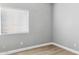 This bedroom features modern gray walls, wood look flooring and a bright window with horizontal blinds at 30663 N 44Th St, Cave Creek, AZ 85331