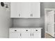 Clean white laundry room with counter, cabinets and black hardware at 30663 N 44Th St, Cave Creek, AZ 85331