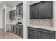 Kitchen featuring gray cabinetry, quartz countertops, and herringbone backsplash at 3650 E Sinclair St, Phoenix, AZ 85050