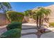 Landscaped backyard featuring manicured bushes, a concrete paver path, and decorative rock accents at 408 E Silverwood Dr, Phoenix, AZ 85048