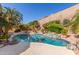 Sparkling backyard pool surrounded by mature landscaping and rock features creating a serene outdoor retreat at 408 E Silverwood Dr, Phoenix, AZ 85048