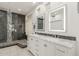Modern bathroom with double sink vanity, glass block window, and luxurious marble shower at 408 E Silverwood Dr, Phoenix, AZ 85048