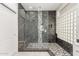 Luxurious walk-in shower featuring glass door, bench, and decorative black and white marble tile at 408 E Silverwood Dr, Phoenix, AZ 85048