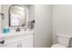 This half bath features a modern vanity with a white countertop and a sleek, dark-framed mirror at 408 E Silverwood Dr, Phoenix, AZ 85048
