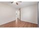 This bedroom offers a clean aesthetic with neutral walls, hardwood floors, and an open doorway to another room at 408 E Silverwood Dr, Phoenix, AZ 85048