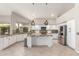 Well-lit kitchen featuring an island, modern appliances, granite countertops, and white cabinetry at 408 E Silverwood Dr, Phoenix, AZ 85048