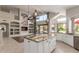 Open floor plan connecting the living room with built-ins to a kitchen with granite countertops and an island at 408 E Silverwood Dr, Phoenix, AZ 85048