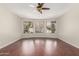 Large living room featuring hardwood floors, ceiling fan, and a large window overlooking the backyard at 408 E Silverwood Dr, Phoenix, AZ 85048