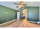 Comfortable bedroom featuring green walls, a ceiling fan, and a doorway to the bathroom at 4702 E Lavender Ln, Phoenix, AZ 85044