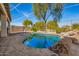 Backyard with a sparkling pool, rock accents and desert landscaping is perfect for outdoor living at 502 E Mountain View Rd, San Tan Valley, AZ 85143