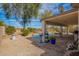 The backyard offers covered patio seating, pool with rock features, and desert landscaping at 502 E Mountain View Rd, San Tan Valley, AZ 85143