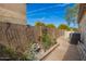 Backyard featuring a brick-paved walkway, flower bed and rock water feature with block wall and blue sky at 502 E Mountain View Rd, San Tan Valley, AZ 85143