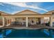 An outdoor covered patio with built in BBQ area overlooks a backyard pool and desert plants at 502 E Mountain View Rd, San Tan Valley, AZ 85143