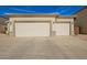 Exterior featuring a three-car garage with neutral colors and desert landscaping at 502 E Mountain View Rd, San Tan Valley, AZ 85143