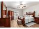 Main bedroom featuring a ceiling fan, shuttered window, and an ornate wood frame bed and dresser at 502 E Mountain View Rd, San Tan Valley, AZ 85143