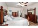 View of the main bedroom featuring a ceiling fan, hardwood floors and ornate wooden furniture at 502 E Mountain View Rd, San Tan Valley, AZ 85143