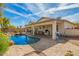 A sparkling pool with a rock waterfall, patio, and covered seating area at 502 E Mountain View Rd, San Tan Valley, AZ 85143