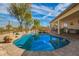 A backyard pool with a rock waterfall feature and covered patio area for entertaining at 502 E Mountain View Rd, San Tan Valley, AZ 85143