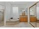 Luxurious bathroom featuring a soaking tub, glass block window, and spacious vanity at 6426 N 27Th St, Phoenix, AZ 85016