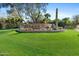 Well-manicured entrance to The Biltmore Estates with verdant lawn, desert plants, and stone signage at 6426 N 27Th St, Phoenix, AZ 85016