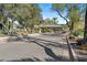 Entrance to the community through a covered gatehouse with mature trees and landscaping at 6426 N 27Th St, Phoenix, AZ 85016