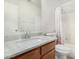 Bright bathroom featuring a granite countertop, a shower over tub with floral curtain, and wood cabinetry at 665 E Winchester Way, Chandler, AZ 85286