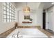 Close-up of a soaking tub with glass-block window and built-in shelf at 6960 E Ivyglen St, Mesa, AZ 85207
