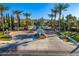 An elevated view of the community entrance featuring mature palm trees, landscaping, and attractive architectural details at 6960 E Ivyglen St, Mesa, AZ 85207