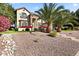 Elegant two-story home featuring stone accents, decorative balconies, and a meticulously landscaped front yard at 6960 E Ivyglen St, Mesa, AZ 85207