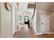 Bright foyer featuring hardwood floors, a curved staircase, and a decorative front door, creating a warm welcome at 6960 E Ivyglen St, Mesa, AZ 85207