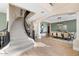 Open foyer with a curved staircase, wood floors, and elegant dining area, creating an inviting space at 6960 E Ivyglen St, Mesa, AZ 85207