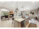 Elegant kitchen featuring an island with a sink, pendant lighting, and an adjoining dining area at 6960 E Ivyglen St, Mesa, AZ 85207