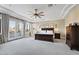Spacious main bedroom with a ceiling fan and French doors leading to a balcony at 6960 E Ivyglen St, Mesa, AZ 85207