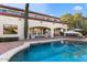 Sparkling pool with elegant patio, sun umbrellas, and beautiful architecture for luxurious outdoor living at 6960 E Ivyglen St, Mesa, AZ 85207