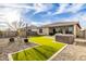 Spacious backyard featuring a hot tub, lush artificial turf, and a neatly designed rock garden at 7533 S Woodchute Dr, Gold Canyon, AZ 85118