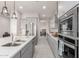 View of kitchen with stainless steel appliances, gray cabinets, quartz countertops, and modern pendant lighting at 7533 S Woodchute Dr, Gold Canyon, AZ 85118