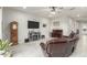 Comfortable living room with tile flooring, fireplace, piano and a comfortable leather sofa at 7533 S Woodchute Dr, Gold Canyon, AZ 85118