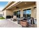 Relaxing covered patio area with comfortable seating, Blackstone grill, and a ceiling fan for enjoying outdoor living at 7533 S Woodchute Dr, Gold Canyon, AZ 85118