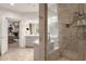 Bright bathroom featuring shower with travertine tile surround and a glass partition at 7740 E Gainey Ranch Rd # 36, Scottsdale, AZ 85258