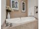 Bright bathroom featuring a standalone bathtub with marble tile surround and modern fixtures at 7740 E Gainey Ranch Rd # 36, Scottsdale, AZ 85258