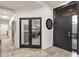 Elegant foyer with travertine floors, black door, and view into a home office space at 7740 E Gainey Ranch Rd # 36, Scottsdale, AZ 85258