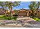 Beautiful single-story home with a two-car garage, mature trees, and a lush green lawn at 7740 E Gainey Ranch Rd # 36, Scottsdale, AZ 85258
