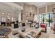 Open-concept living area with stone fireplace, travertine details, and backyard access at 7740 E Gainey Ranch Rd # 36, Scottsdale, AZ 85258